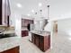 Modern kitchen featuring granite countertops, stainless steel appliances, dark wood cabinetry, and an island with a sink at 1401 Parker Den Dr, Ruskin, FL 33570