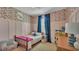 Colorful bedroom with playful wallpaper, a twin bed, and a cozy reading chair at 15706 Starling Water Dr, Lithia, FL 33547
