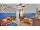 Vibrant room with playful Mario-themed wallpaper, a twin bed, and an orange sofa at 15706 Starling Water Dr, Lithia, FL 33547