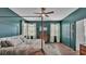Main bedroom with hardwood flooring, canopy bed, ceiling fan, and neutral colored carpet at 15706 Starling Water Dr, Lithia, FL 33547