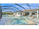 Wide angle of a screened-in pool and hot tub area next to a white home at 15706 Starling Water Dr, Lithia, FL 33547