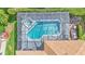 Aerial view of a screened-in pool featuring a large deck and lush landscaping around the perimeter at 15706 Starling Water Dr, Lithia, FL 33547