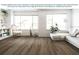Modern living room showcasing vinyl plank flooring and natural light from large windows at 2556 58Th E Cir, Palmetto, FL 34221