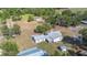 Aerial view of a white home with a metal roof surrounded by mature trees and green lawn at 4020 Mcintosh Rd, Dover, FL 33527
