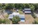 Aerial view showcases the main house, outbuildings, and the property's silver metal roof at 4020 Mcintosh Rd, Dover, FL 33527