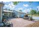 Back patio with an outdoor seating area and brick flooring, connecting to the garage at 4020 Mcintosh Rd, Dover, FL 33527
