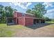 Exterior shot of a large, red barn with lean-to structures and green grass at 4020 Mcintosh Rd, Dover, FL 33527