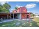 Exterior shot of a large, red barn with lean-to structures at 4020 Mcintosh Rd, Dover, FL 33527