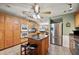 This open kitchen features a center island, stainless steel appliances, and wooden cabinets at 4020 Mcintosh Rd, Dover, FL 33527