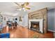 This open-concept living room features a fireplace with rustic wood paneling and hardwood floors at 4020 Mcintosh Rd, Dover, FL 33527