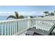Balcony seating overlooking the ocean with palm trees in the distance under a bright blue sky at 4778 Coquina Key Se Dr # 4778, St Petersburg, FL 33705
