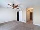 Bedroom with carpet, ceiling fan, barn door closet, and an open doorway to a hallway at 4778 Coquina Key Se Dr # 4778, St Petersburg, FL 33705