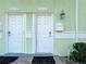 Close-up of the condo's entrance featuring white doors and a vintage-style lantern and mailbox at 4778 Coquina Key Se Dr # 4778, St Petersburg, FL 33705
