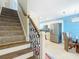 Inviting foyer with a carpeted staircase, modern railing, and an open view of the dining area at 4778 Coquina Key Se Dr # 4778, St Petersburg, FL 33705