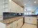 Spacious kitchen featuring granite countertops, white cabinets, and stainless steel appliances at 4778 Coquina Key Se Dr # 4778, St Petersburg, FL 33705