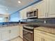 Bright kitchen features granite countertops, stainless appliances, and stylish dark backsplash at 4778 Coquina Key Se Dr # 4778, St Petersburg, FL 33705
