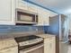 Modern kitchen features stainless steel appliances, granite countertops, and dark backsplash at 4778 Coquina Key Se Dr # 4778, St Petersburg, FL 33705