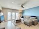 Bright living room with waterfront views through large sliding glass doors and ceiling fan at 4778 Coquina Key Se Dr # 4778, St Petersburg, FL 33705