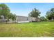 Backyard with a large, well-maintained lawn, enclosed by a fence and surrounded by mature trees at 6433 Mangrove Dr, Wesley Chapel, FL 33544
