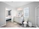 Bright bathroom with a vanity, toilet, and window, conveniently located next to the main bedroom at 6433 Mangrove Dr, Wesley Chapel, FL 33544