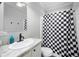 Bathroom featuring a vanity with a sink, toilet, and a shower with a black and white checkered curtain at 6433 Mangrove Dr, Wesley Chapel, FL 33544