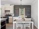 Bright dining area featuring a rustic accent wall, modern chandelier and wood-look floors at 6433 Mangrove Dr, Wesley Chapel, FL 33544