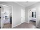 Hallway view with access to the kitchen, the laundry room, and a bedroom at 6433 Mangrove Dr, Wesley Chapel, FL 33544