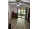 Bedroom with a ceiling fan, wood-look flooring and sliding glass doors leading to an enclosed lanai at 135 Wild Palm Dr, Bradenton, FL 34210