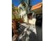A close-up of a condo entrance featuring a fenced-in yard with gravel and tropical foliage at 135 Wild Palm Dr, Bradenton, FL 34210