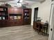 Living room with wood look floors featuring custom built-in shelving with drawers and cabinets for storage at 135 Wild Palm Dr, Bradenton, FL 34210