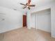 Bright bedroom features tile floors, a ceiling fan, closet and a door at 3205 N 66Th St, Tampa, FL 33619