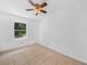 Bright bedroom features tile floors, a ceiling fan, and a window offering natural light at 3205 N 66Th St, Tampa, FL 33619
