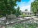 Back exterior of the home with mature trees and partial lattice surround at 3205 N 66Th St, Tampa, FL 33619