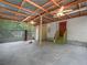 Spacious garage featuring a corrugated metal roof, fans and access to a fenced enclosure at 3205 N 66Th St, Tampa, FL 33619