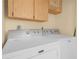 Bright laundry room area featuring Maytag washer and dryer units and upper cabinets at 3205 N 66Th St, Tampa, FL 33619