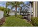 Beautiful backyard featuring well-maintained lawn and lush tropical landscaping near screened lanai at 3419 Trapnell Ridge Dr, Plant City, FL 33567