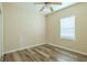 Cozy bedroom with wood-look flooring, a ceiling fan, and a window allowing natural light at 3419 Trapnell Ridge Dr, Plant City, FL 33567