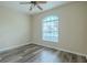 Well-lit bedroom with wood-look flooring, large window, and a ceiling fan at 3419 Trapnell Ridge Dr, Plant City, FL 33567