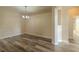 Dining room showcasing modern chandelier, wood flooring, and neutral wall colors at 3419 Trapnell Ridge Dr, Plant City, FL 33567