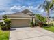 Well-maintained home featuring a wide driveway, manicured landscaping, and attached two-car garage at 3419 Trapnell Ridge Dr, Plant City, FL 33567