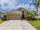 Charming home with a spacious driveway, a two-car garage, and tropical landscaping at 3419 Trapnell Ridge Dr, Plant City, FL 33567