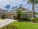 Charming one-story home features a lush front yard, mature landscaping, and an attached two-car garage at 3419 Trapnell Ridge Dr, Plant City, FL 33567