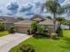 Beautiful one-story home with a manicured lawn, complemented by tropical landscaping and a private two-car garage at 3419 Trapnell Ridge Dr, Plant City, FL 33567