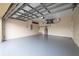 Spacious two car garage with an epoxy floor and a modern garage door opener at 3419 Trapnell Ridge Dr, Plant City, FL 33567