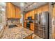 Close-up view of kitchen with stainless steel appliances, granite counters, and wooden cabinets at 3419 Trapnell Ridge Dr, Plant City, FL 33567