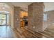 Open floor plan with wood flooring, brick accents, and a glimpse of the front entrance at 3419 Trapnell Ridge Dr, Plant City, FL 33567