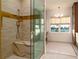 Elegant bathroom with a glass-enclosed shower, gold fixtures, and a comfortable marble bench at 531 68Th St, Holmes Beach, FL 34217