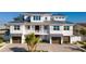 Stunning three-story coastal home with gray roof, white siding, and attached garages at 531 68Th St, Holmes Beach, FL 34217