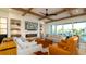 Bright living room with a modern fireplace, beamed ceiling, and views of the outside waterway at 531 68Th St, Holmes Beach, FL 34217