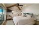 Main bedroom with white furnishings, beamed ceiling, and scenic view through large sliding glass doors at 531 68Th St, Holmes Beach, FL 34217
